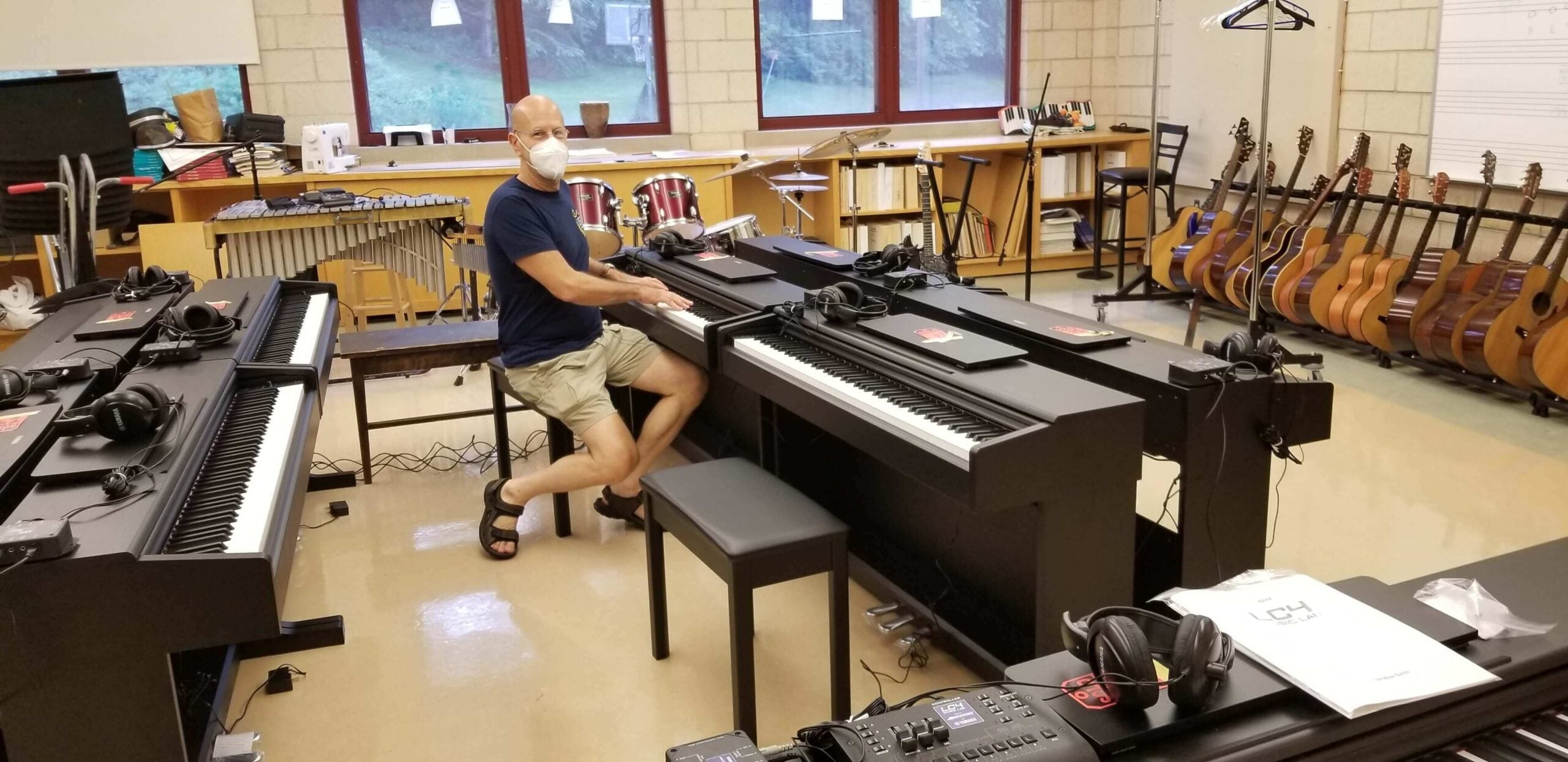 Man in a room full of pianos and guitars